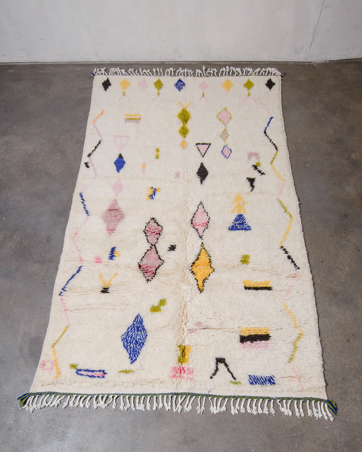Berberlin Azilal rug made of fluffy wool, laying flat on a concrete floor.